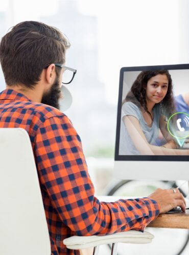 Man sitting at desk and making a video call on desktop computer